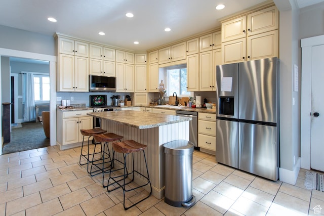 465 S Main St, Providence, UT 84332 - kitchen featuring cream cabinets, appliances with stainless steel finishes, a healthy amount of sunlight, and a center island