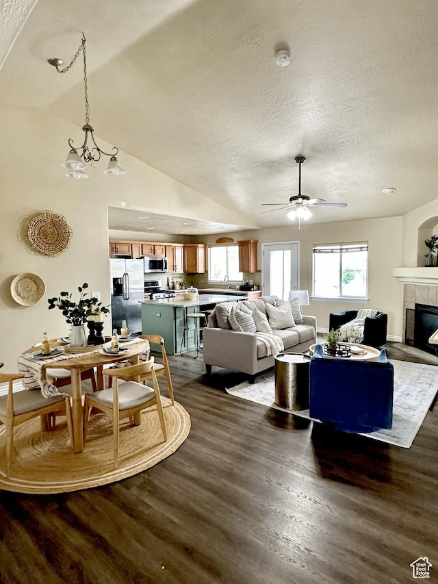 126 W Casi Way, Saratoga Springs, UT 84045 - living room with a textured ceiling, dark wood-type flooring, healthy amount of natural light, a ceiling fan, and a tiled fireplace