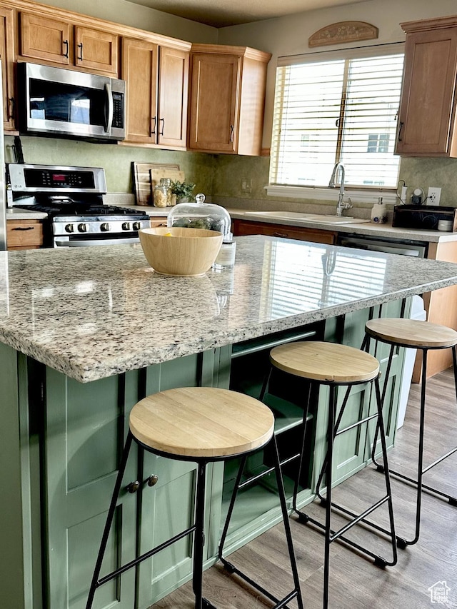 126 W Casi Way, Saratoga Springs, UT 84045 - kitchen with appliances with stainless steel finishes, light wood finished floors, tasteful backsplash, and a center island