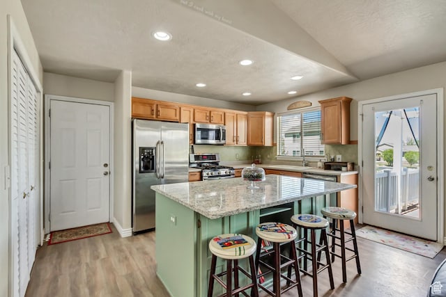 126 W Casi Way, Saratoga Springs, UT 84045 - kitchen featuring appliances with stainless steel finishes, a kitchen island, light wood-type flooring, a kitchen bar, and recessed lighting