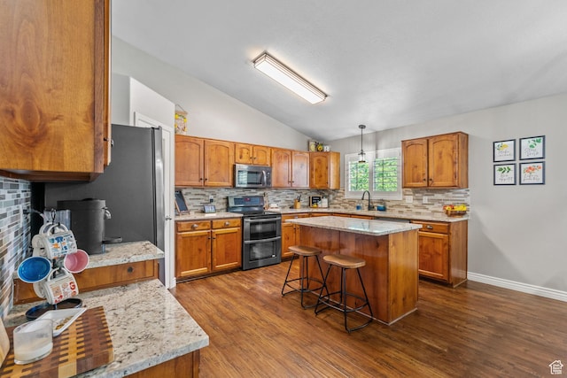 2582 W 1890 N, Clinton, UT 84015 - kitchen featuring brown cabinets, dark wood finished floors, stainless steel appliances, lofted ceiling, and tasteful backsplash