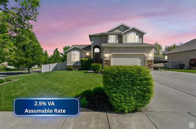traditional-style house with a front yard, a garage, stone siding, and stucco siding