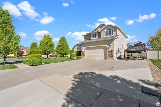 2582 W 1890 N, Clinton, UT 84015 - view of front facade featuring fence, stone siding, stucco siding, concrete driveway, and an attached garage