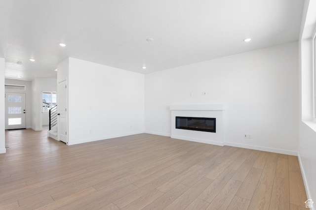894 S 1100 W, American Fork, UT 84003 - unfurnished living room featuring recessed lighting, light wood-style floors, baseboards, and a glass covered fireplace