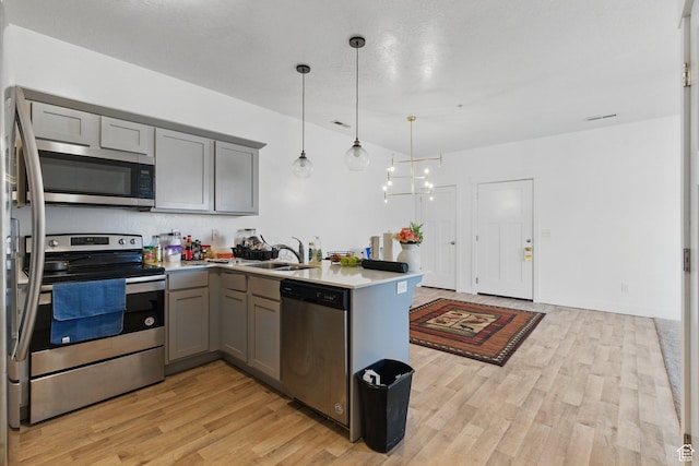 3647 W 1530 N Unit Hh204, Lehi, UT 84043 - kitchen featuring appliances with stainless steel finishes, gray cabinetry, a sink, light wood finished floors, and a peninsula