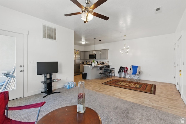 3647 W 1530 N Unit Hh204, Lehi, UT 84043 - living room featuring ceiling fan with notable chandelier, light wood finished floors, and visible vents
