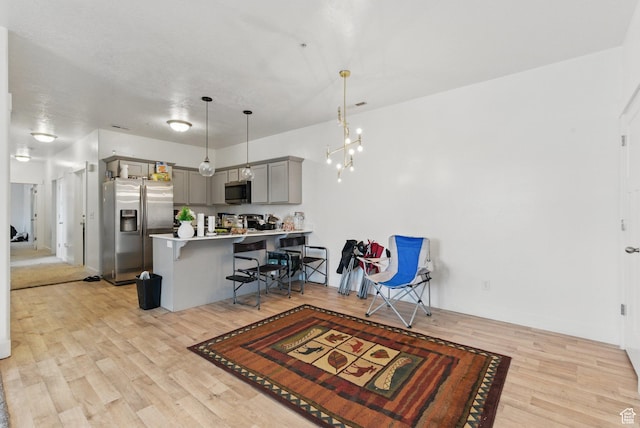 3647 W 1530 N Unit Hh204, Lehi, UT 84043 - kitchen featuring a peninsula, a kitchen breakfast bar, light wood-style flooring, gray cabinetry, and stainless steel appliances