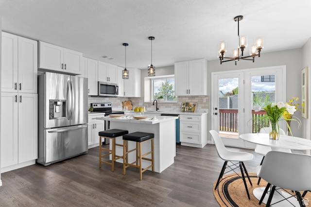 3559 W Lexington View Dr, West Jordan, UT 84088 - kitchen featuring appliances with stainless steel finishes, an inviting chandelier, a sink, light countertops, and backsplash