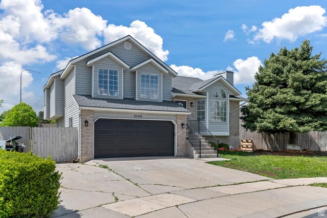 3559 W Lexington View Dr, West Jordan, UT 84088 - split level home featuring fence, an attached garage, driveway, and brick siding