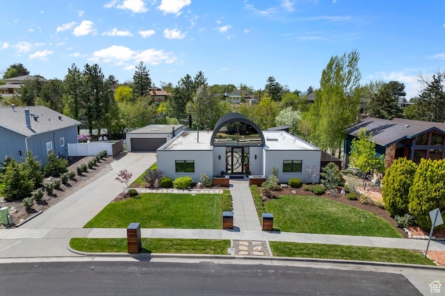 view of front facade featuring a garage, a front lawn, and a residential view