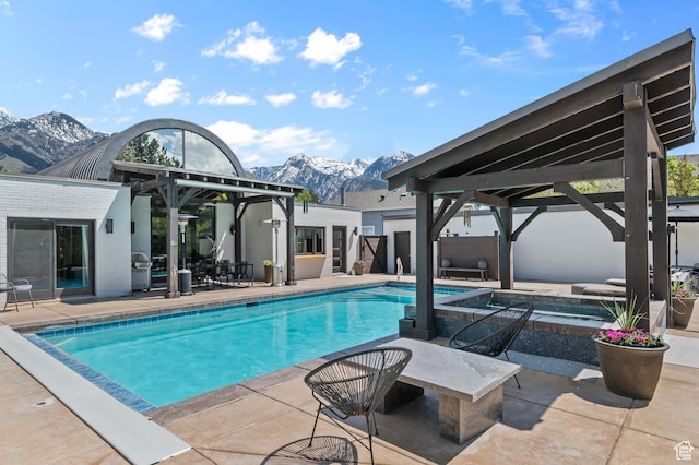 pool with a gazebo, a mountain view, an in ground hot tub, and a patio area