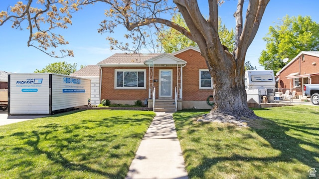 bungalow-style home with brick siding and a front lawn