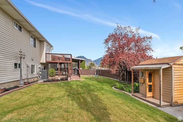 2363 W 960 N, Provo, UT 84601 - view of yard featuring a deck with mountain view, a fenced backyard, an outbuilding, central AC unit, and a playground
