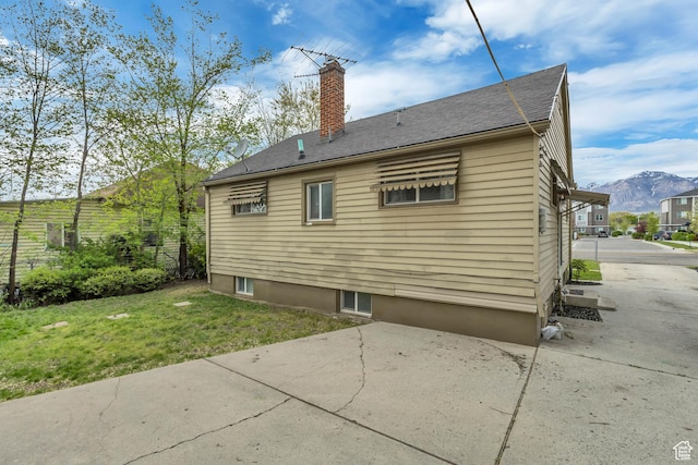 133 E 7th St S, Ogden, UT 84404 - back of property featuring a yard, a patio, a chimney, and a mountain view