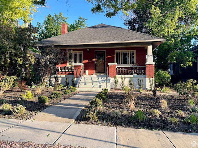 970 E Wilson Ave S, Salt Lake City, UT 84105 - view of front of house with a porch, brick siding, a chimney, and roof with shingles