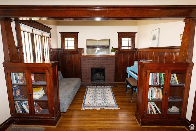 970 E Wilson Ave S, Salt Lake City, UT 84105 - living area featuring wainscoting, wood finished floors, plenty of natural light, wood walls, and a brick fireplace
