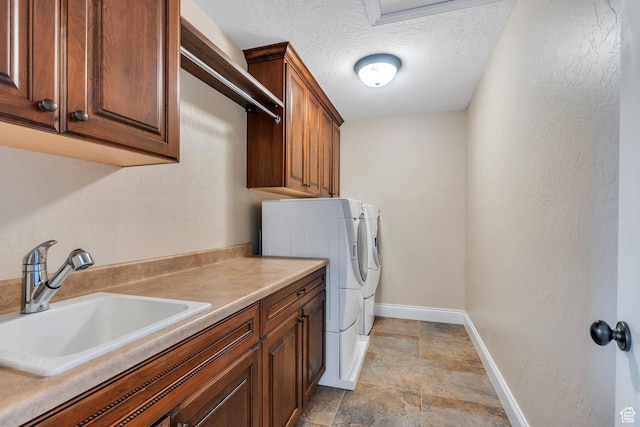 2797 W Fox Hunters Loop, Lehi, UT 84043 - clothes washing area with stone finish floor, washing machine and dryer, cabinet space, a sink, and baseboards