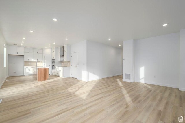 246 E Wasatch Ave Unit 201, Midvale, UT 84070 - unfurnished living room with recessed lighting, light wood-style floors, baseboards, and a sink