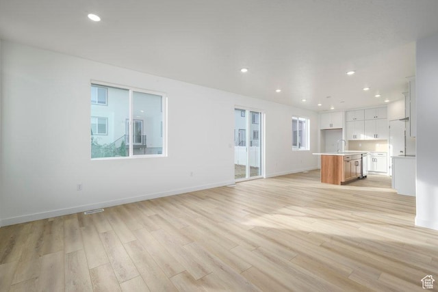 246 E Wasatch Ave Unit 201, Midvale, UT 84070 - unfurnished living room with light wood finished floors, recessed lighting, and baseboards
