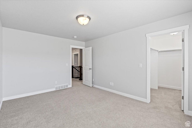 4264 W Abbey Bend Ln, Herriman, UT 84096 - unfurnished bedroom with a walk in closet, light colored carpet, baseboards, and a closet