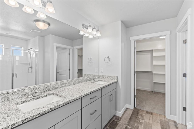 4264 W Abbey Bend Ln, Herriman, UT 84096 - bathroom with a stall shower, hardwood / wood-style flooring, double vanity, baseboards, and a spacious closet