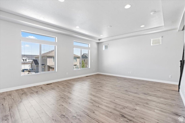 4264 W Abbey Bend Ln, Herriman, UT 84096 - unfurnished living room featuring a raised ceiling, light wood finished floors, baseboards, and recessed lighting