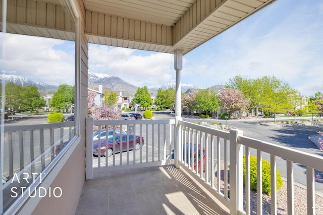 balcony with covered porch, a residential view, and a mountain view