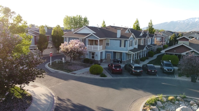 view of road featuring a residential view, a mountain view, traffic signs, and curbs