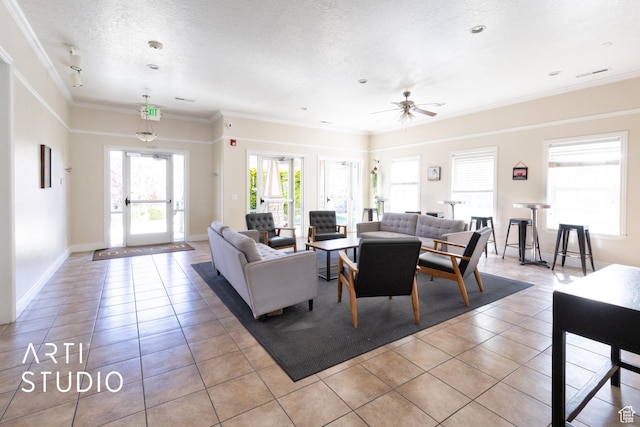 living room with crown molding, ceiling fan, baseboards, light tile patterned floors, and visible vents