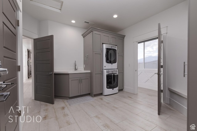 3658 W 2510 S, Hurricane, UT 84737 - kitchen with stacked washer and clothes dryer, a sink, light wood-type flooring, gray cabinets, and visible vents