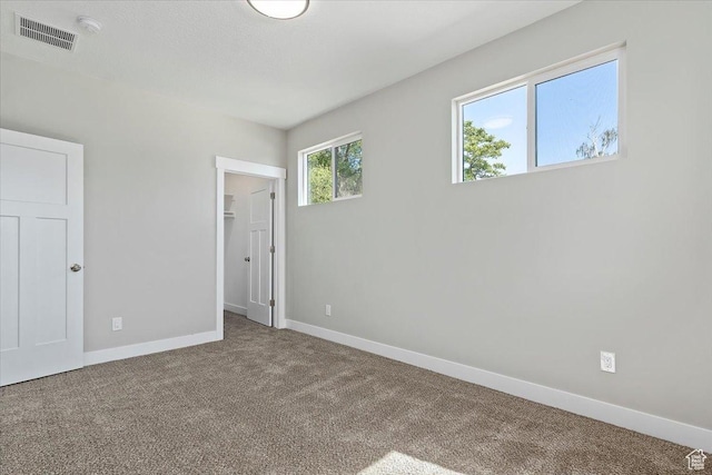 404 W 2700 S, Bountiful, UT 84010 - unfurnished bedroom with a closet, baseboards, carpet flooring, visible vents, and a walk in closet