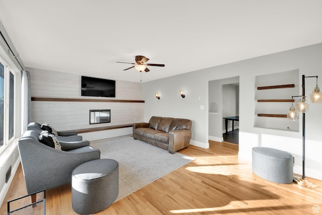 257 E Kingdon S, North Salt Lake, UT 84054 - living room with a fireplace, wood walls, a ceiling fan, baseboards, and wood finished floors
