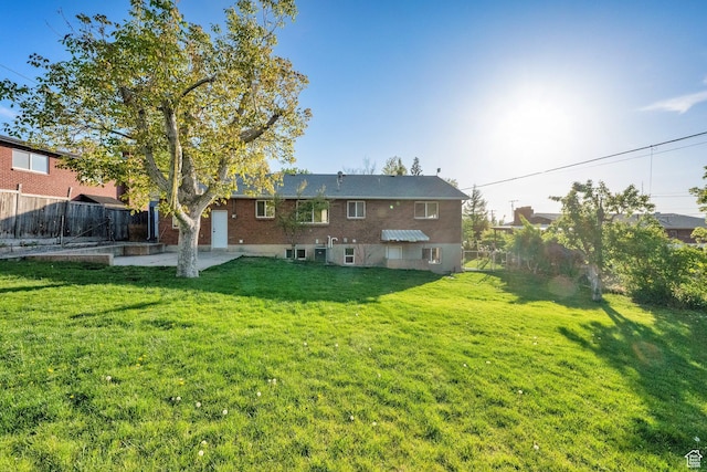 257 E Kingdon S, North Salt Lake, UT 84054 - back of property featuring a lawn, a patio, and a fenced backyard