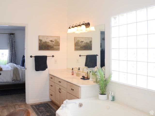 1087 E Fort Pierce Dr, St George, UT 84790 - ensuite bathroom with connected bathroom, vanity, baseboards, wood finished floors, and a bath