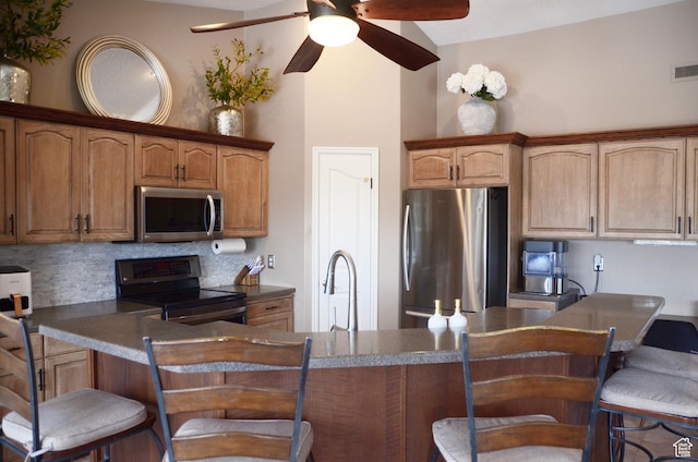 1087 E Fort Pierce Dr, St George, UT 84790 - kitchen with a kitchen bar, dark countertops, tasteful backsplash, a sink, and stainless steel appliances