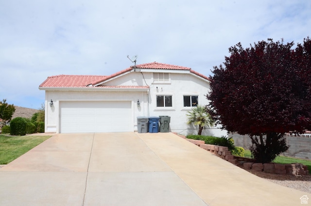 1087 E Fort Pierce Dr, St George, UT 84790 - mediterranean / spanish-style house featuring concrete driveway, an attached garage, a tile roof, and stucco siding