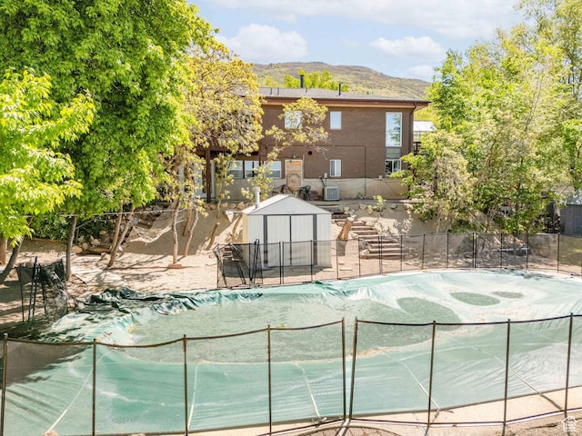 1340 E Oakmont Ln, Fruit Heights, UT 84037 - view of pool with fence, an outdoor structure, a mountain view, a shed, and a fenced in pool