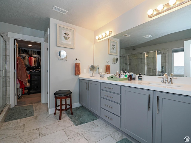 10953 S Kelso Dune Dr, South Jordan, UT 84009 - bathroom featuring double vanity, visible vents, a stall shower, a sink, and a spacious closet