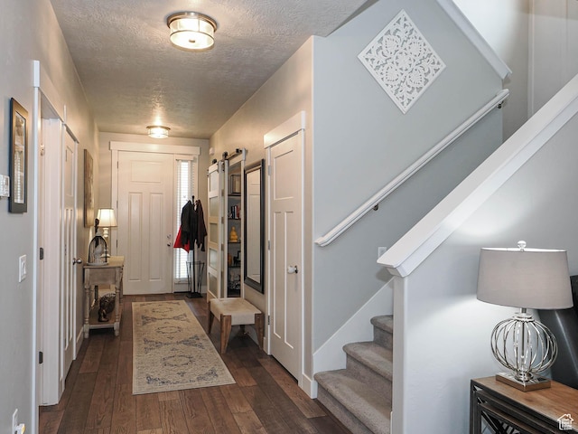 10953 S Kelso Dune Dr, South Jordan, UT 84009 - foyer entrance featuring a textured ceiling, stairs, dark wood-style floors, and a barn door