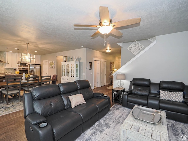 10953 S Kelso Dune Dr, South Jordan, UT 84009 - living room featuring ceiling fan with notable chandelier, a textured ceiling, and dark wood-type flooring