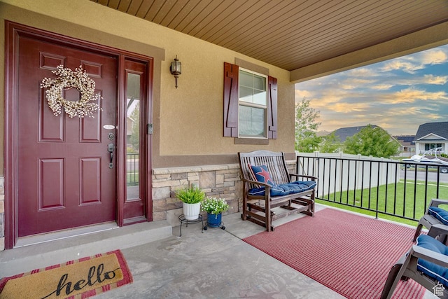 2130 S 450 E, Heber City, UT 84032 - exterior entry at dusk with covered porch, stucco siding, and stone siding