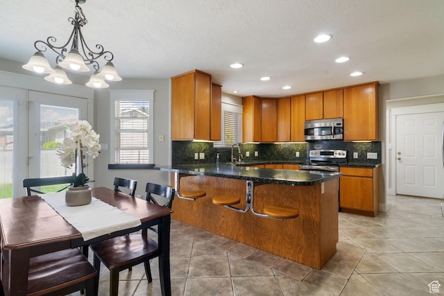 2295 E 2150 N, Layton, UT 84040 - kitchen featuring a peninsula, appliances with stainless steel finishes, brown cabinetry, and a sink