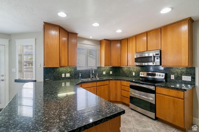 2295 E 2150 N, Layton, UT 84040 - kitchen with a sink, dark stone counters, stainless steel appliances, and brown cabinets