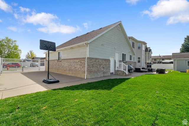 2295 E 2150 N, Layton, UT 84040 - view of side of home with fence, brick siding, a gate, a patio area, and a lawn