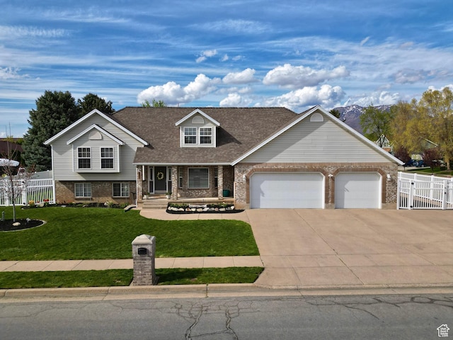2295 E 2150 N, Layton, UT 84040 - split level home with concrete driveway, brick siding, fence, and a garage