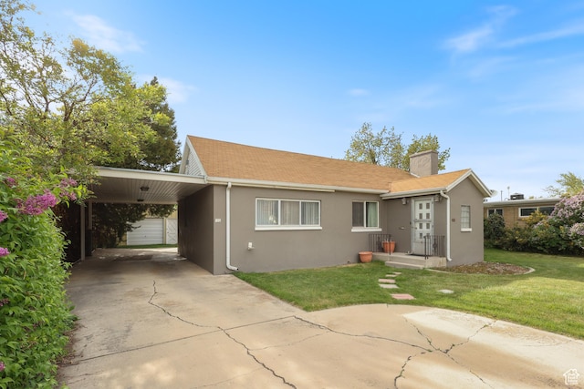 view of front facade featuring a front lawn, stucco siding, an attached carport, a chimney, and driveway