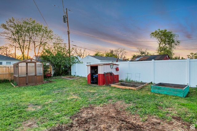 1072 S 1400 W, Salt Lake City, UT 84104 - yard at dusk featuring an exterior structure, a garden, fence, and an outbuilding
