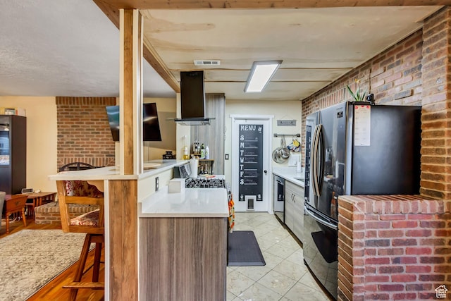 1072 S 1400 W, Salt Lake City, UT 84104 - kitchen featuring island exhaust hood, freestanding refrigerator, brick wall, and light countertops