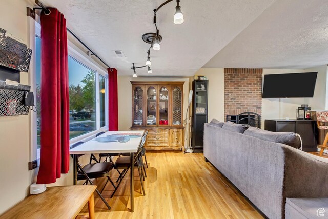1072 S 1400 W, Salt Lake City, UT 84104 - interior space featuring a fireplace, light wood finished floors, a textured ceiling, and visible vents
