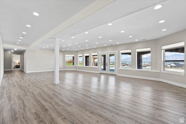 3630 S Panorama Dr W, Saratoga Springs, UT 84045 - unfurnished living room featuring baseboards, recessed lighting, light wood-style flooring, and a wealth of natural light